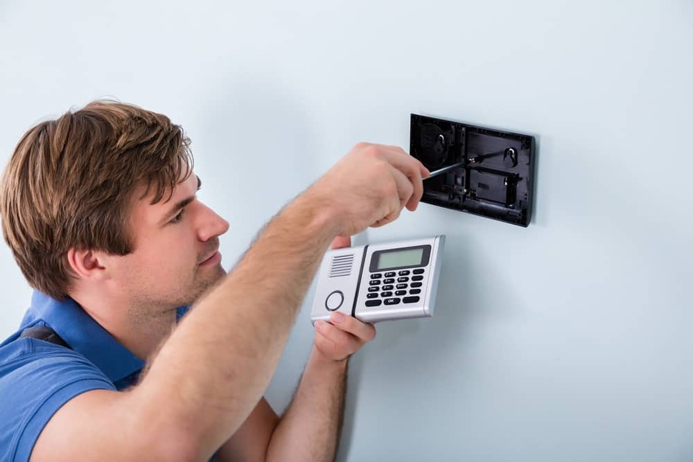 Technician Installing Security System Using Screwdriver