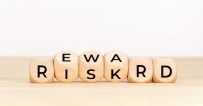Image of several deice initially spelling out "Risk" then rolling over to spell "Reward."